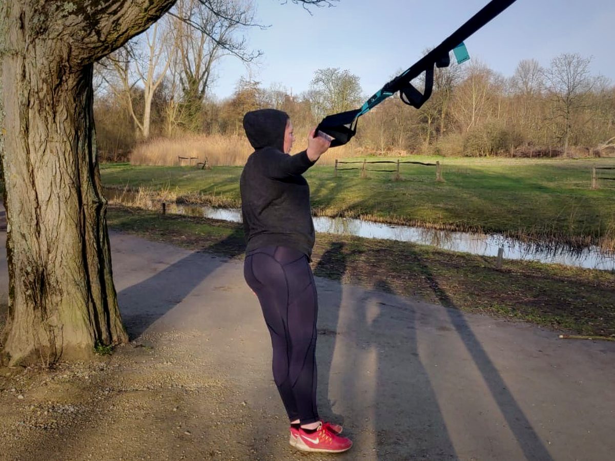 Iemand trekt zich op aan een ophangsysteem aan een boom